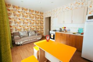 cocina con mesa amarilla y sofá en una habitación en Apart Hotel Clover, en Irkutsk