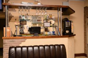 a bar with a black leather bench in front of it at Hotel Hizhina in Petropavlovsk