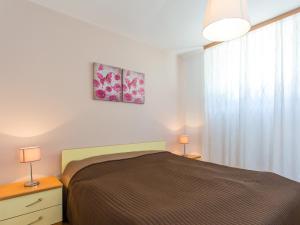 a bedroom with a bed and two lamps and a window at Apartments Špadići in Poreč