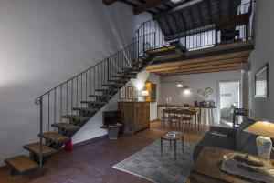 a living room with a spiral staircase and a dining room at Casa Vacanze Le Fornaci in Laterina