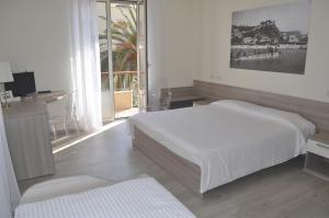 a hotel room with a bed, desk and a painting on the wall at Hotel Boncardo in Finale Ligure