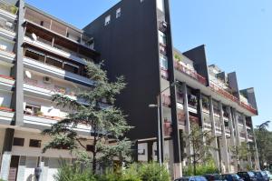 Un edificio negro con coches aparcados delante. en Trani Rent Rooms, en Trani
