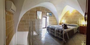 a bedroom with a bed in a room with an archway at Corte De Noie Appartamenti Gallipoli in Gallipoli