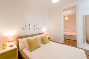 um quarto com uma cama com pássaros na parede em Cozy Apartment with Castel view em Lisboa