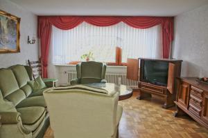 a living room with a couch and a tv at Ferienhaus am Doctorberg in Bernkastel-Kues +3 photos