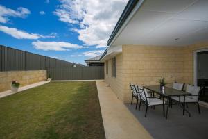 a patio with a table and chairs in a yard at Indian Ocean Retreat in Alkimos +17 photos