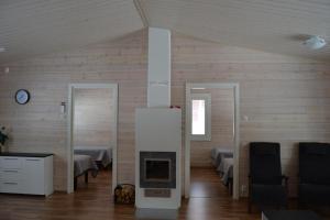 a room with a fireplace and a room with two beds at Ruoke Holiday Village in Kesälahti
