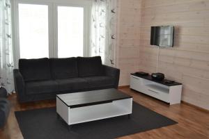a living room with a couch and a tv at Ruoke Holiday Village in Kesälahti