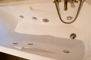 d'une baignoire blanche avec un lavabo en or. dans l'établissement Villa Jades Sardinia, à San Gregorio