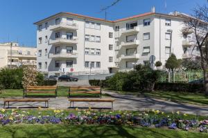 a building with benches in a park with flowers at Zadera Accommodation in Zadar