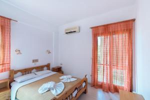 a bedroom with a bed with two towels on it at Hotel Eva Marina in Matala