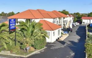 una casa con techo naranja junto a una calle en Northcote Motor Lodge en Christchurch