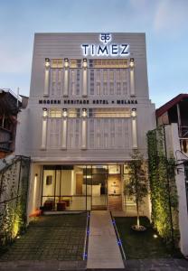 a building with a sign on the front of it at Timez Hotel Melaka in Melaka