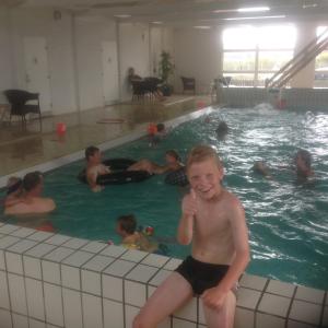 Ein kleiner Junge, der im Pool sitzt. in der Unterkunft Thorsminde Camping & Cottages in Thorsminde