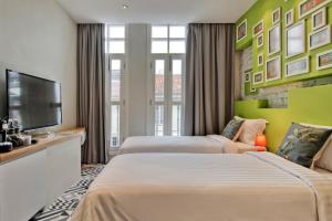 Postel nebo postele na pokoji v ubytování Timez Hotel Melaka