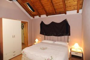 a bedroom with a white bed with a black head board at Roccetta Fiorita in Pettenasco