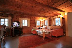 ein Wohnzimmer mit einem Sofa und einem TV in der Unterkunft Oberlausitzer Ferienhaus Gebirgshäusl Jonsdorf in Kurort Jonsdorf