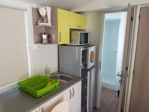 a small kitchen with a sink and a microwave at Kamp Rujno in Starigrad