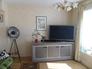 a living room with a flat screen tv on a entertainment center at Le Lyon Vert in Commentry