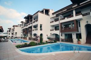 a hotel with a swimming pool in front of a building at White Coast Beach Apartments in Kavarna