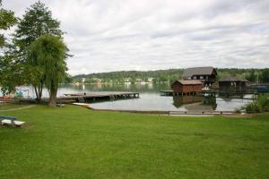 a lake with a dock and a house on the water at Bungalows Karin in Sankt Kanzian