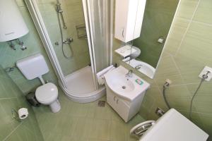 ein Badezimmer mit Waschbecken, Toilette und Dusche in der Unterkunft Holiday House Palma in Dobrinj