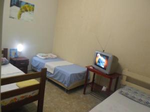 um pequeno quarto com 2 camas e uma televisão em Hotel Palmas Tocantins em Palmas