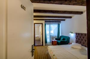 sypialnia z łóżkiem i niebieskim krzesłem w obiekcie Resort Cheile Gradistei Moieciu w mieście Moieciu de Sus