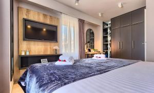 a bedroom with a large bed with a flat screen tv on the wall at Apartment Mondo Deluxe in Kaštela