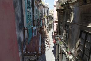 een smal steegje met een slang tussen twee gebouwen bij Il Fuoco di Archimede - Ortigia in Siracusa