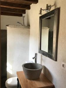 a bathroom with a sink and a mirror and a toilet at U Fragnu in Omessa