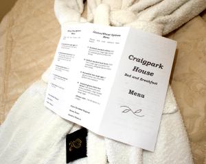 um menu de hotel em cima de uma toalha branca em Craig Park House em Airdrie