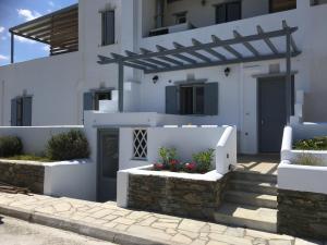 a white house with flowers in a courtyard at Boussetil Apartment in Tinos