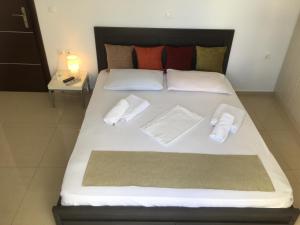 a large bed with white sheets and pillows on it at Boussetil Apartment in Tinos