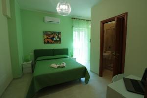 una camera verde con un letto con scarpe sopra di B&B Casati81 a Roma
