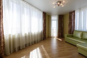 salon z zasłonami i zieloną kanapą w obiekcie Nataliya's flat apartments Shcherbakovskiy pereulok 7 w Kazaniu