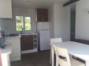 a kitchen with a table and a white refrigerator at Albaluce Village Viverone in Viverone