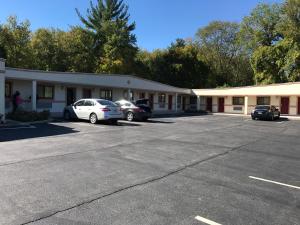 a building with two cars parked in a parking lot at Skyview Motor Inn in Johnston