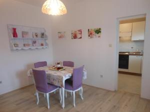 a dining room with a table and purple chairs at Donami Apartments in Pag +82 photos