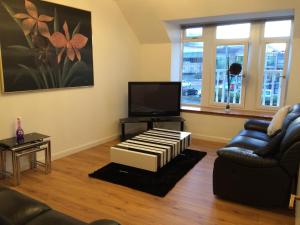 a living room with a couch and a television at Eastgate Apartment in Inverness