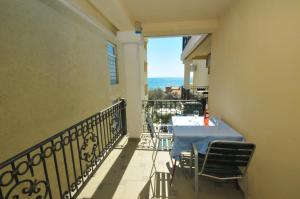 a balcony with a table and a view of the ocean at Apartments Balic in Sveti Stefan