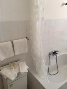 a white bathroom with a tub and a shower at Apartamento Casino Praia in Figueira da Foz +27 photos