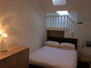 a bedroom with a bed and a staircase at Eastgate Apartment in Inverness
