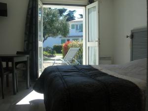 a bedroom with a bed and a sliding glass door at Le Parasol in Ars-en-Ré