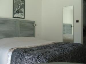 a bedroom with a large bed and a mirror at Le Parasol in Ars-en-Ré