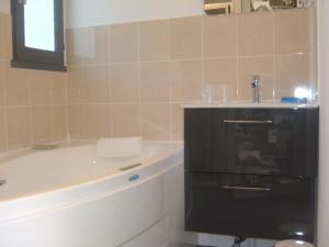 a bathroom with a bath tub and a sink at Le Parasol in Ars-en-Ré