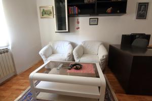 Sala de estar con 2 sillas blancas y mesa de centro en Apartment Lavanda 1 - Zagreb en Zagreb