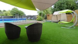 a lawn with two chairs and a tent and a pool at Le Parasol in Ars-en-Ré
