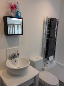 a white bathroom with a sink and a toilet at Eastgate Apartment in Inverness +43 photos