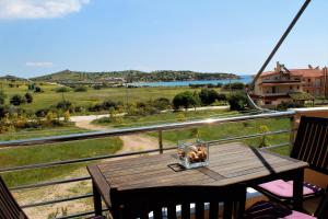 a wooden table on a balcony with a view at Helen's Sounio Apartments in Sounio